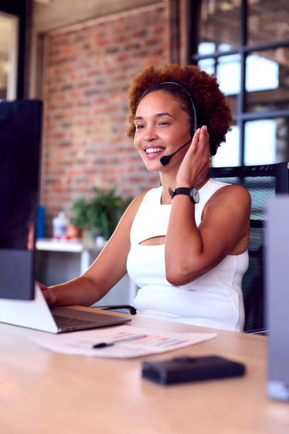 istock Businesswoman Wearing Headset At Computer In Customer Support Centre 1470930938