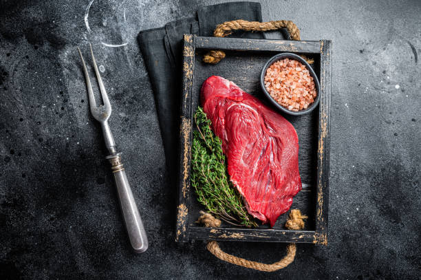 istock Fresh Raw veal meat with herbs and salt. Black background. Top view 1470932012