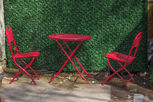 Red Table with two red chairs with green background , Tbilisi,  Georgia