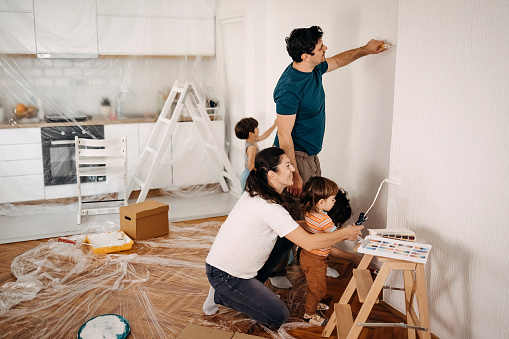 Parents and their children paint an apartment