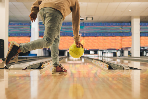 Young man in bowling alley having fun, the sporty man holding a bowling ball