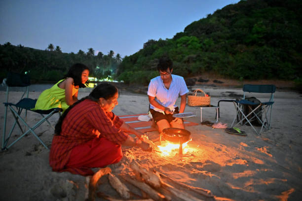 istock Three-generation family having a Barbeque on the beach at twilight 1470934148