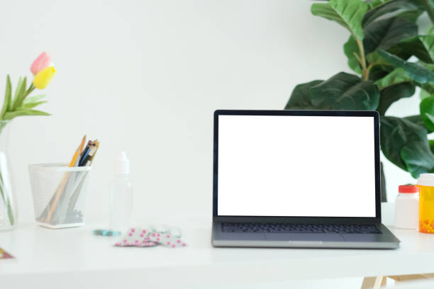 istock Laptop mock up, Laptop computer with blank screen and medicines on doctor table 1470934676