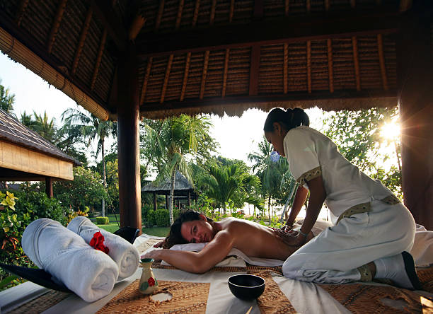 A woman getting a massage in a tropical settings stock photo