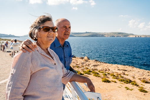 Beautiful senior tourist couple looking at view from the seaside in Malta.