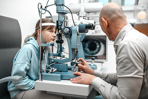 Beautiful young girl during a precise fitting measurement for contact lenses at an opticians