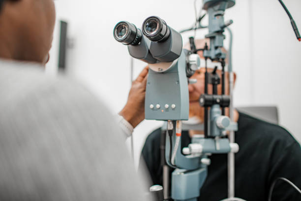 black female optician during a contact lens fitting with a client - human eye eyesight optometrist lens imagens e fotografias de stock