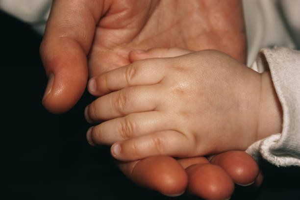 istock Close-up: mother holds her daughter's hand in her hand. 1470939702