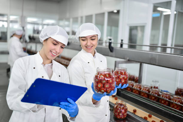 istock Smiling Female Workers Comparing Jar Weights With Stuffed Peppers In Food Processing Plant 1470940235