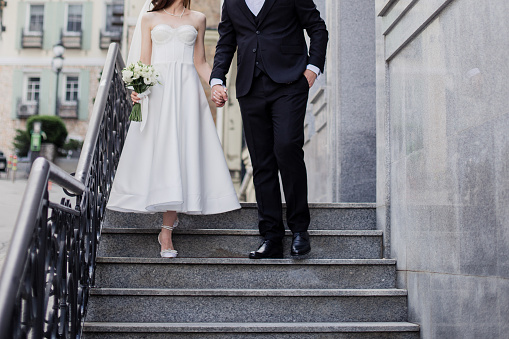 groom and the bride in a wedding dress together with a wedding bouquet