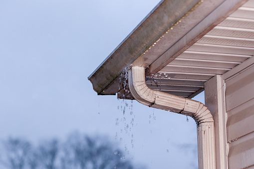 Water coming out of gutter on the roof of a residential home