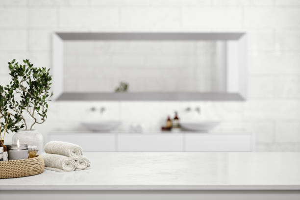 White Marble Countertop In Luxury Bathroom White marble countertop with hand towels, soap, shampoo, aroma candle and diffuser. domestic bathroom stock pictures, royalty-free photos & images