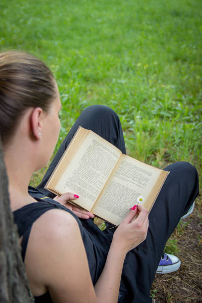 istock Young girl reading a book 1470955238