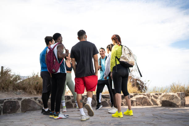 Fitness, hug and portrait of athlete friends in stadium for bonding, competition or support. Exercise, smile and teamwork with group of happy people outdoor at venue for health, training or workout
