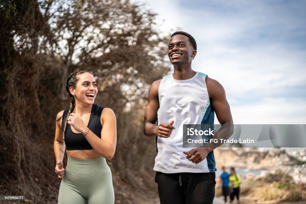 Friends talking while running outdoors Exercising Stock Photo