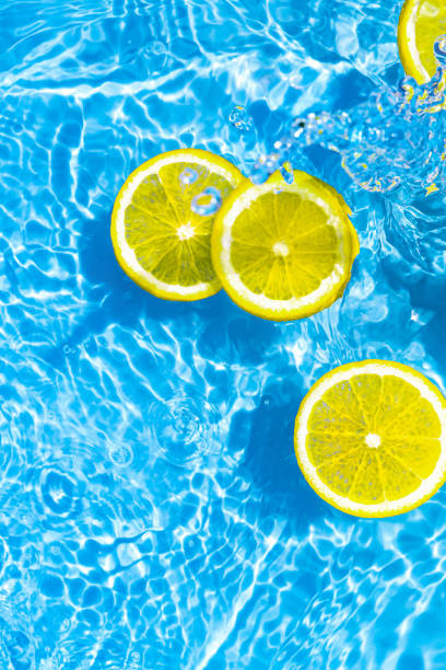 istock Creative summer composition made of sliced lemon in transparent blue water. Refreshment concept. Healthy refreshing drink theme. Top view 1470956241