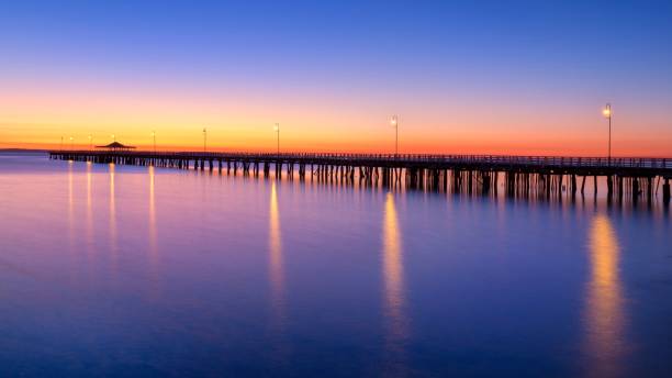 istock a pier is lit up at night by the water's edge 1470956536