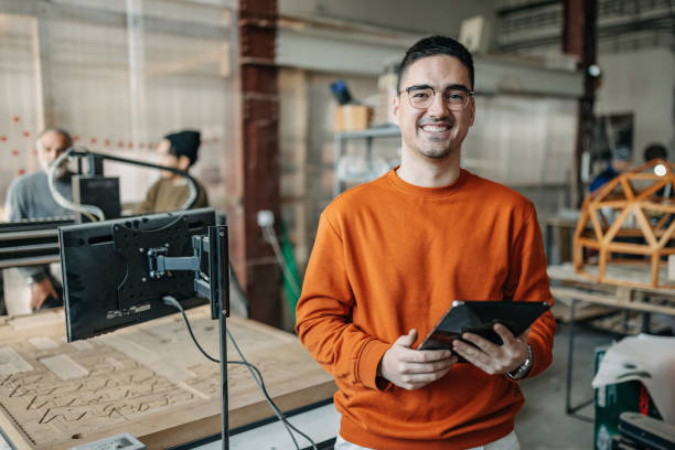 University student holding laptop in the workshop portrait stock photo
