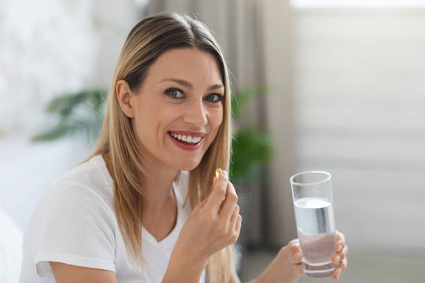 istock Smiling pretty woman taking pill after waking up 1470959032
