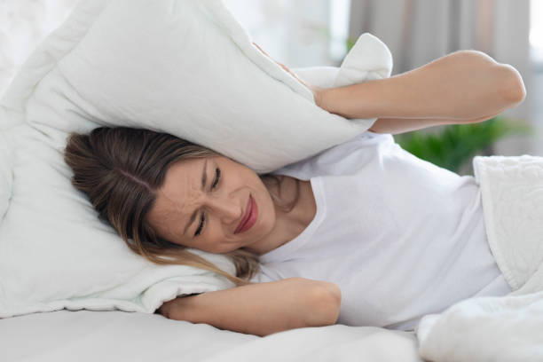 istock Furious sleepless young woman covering her head with pillow 1470959038