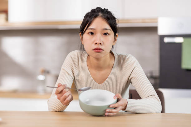 空の皿を見せている不幸な中国人女性