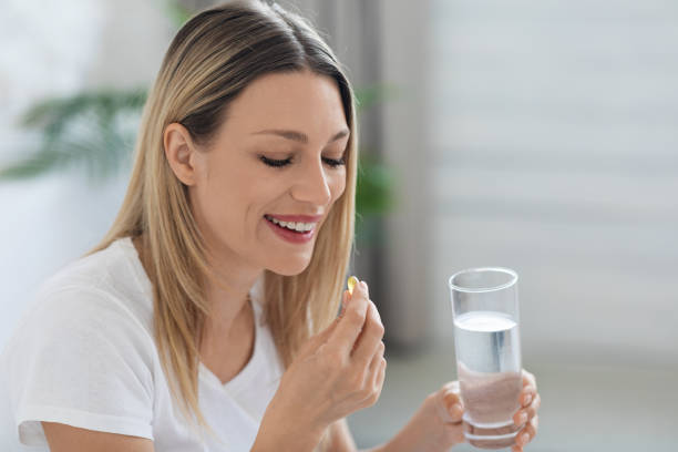 istock Smiling pretty woman taking pill after waking up, copy space 1470959238