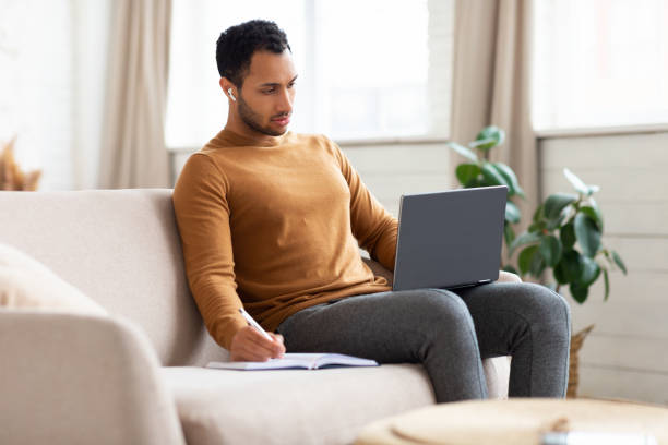 istock Portrait of focused Arab man using laptop taking notes 1470959295