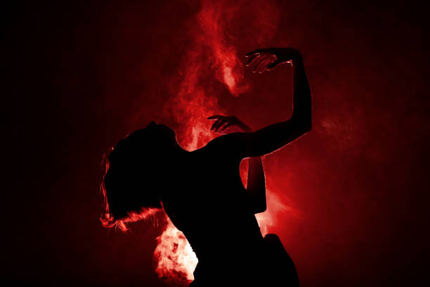 Silhouette modern ballet dancer. Ballerina posing against black with smoke in the background stock photo