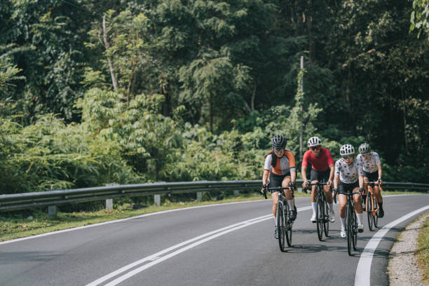 asiatisch-chinesische radsportlerin führt bei ländlichem radrennen - mixed age stock-fotos und bilder