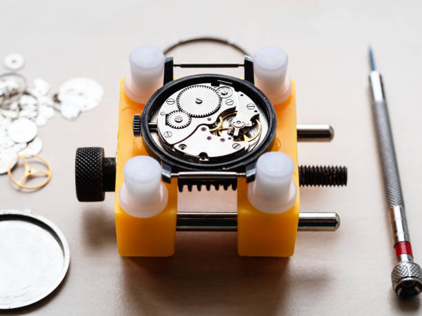 open mechanical watch in yellow holder closeup stock photo
