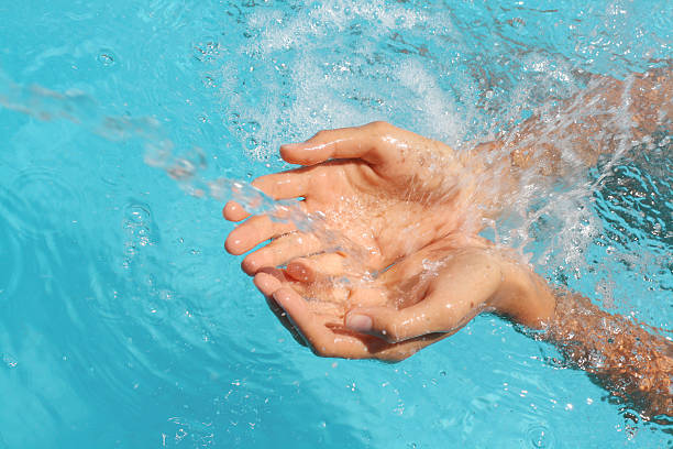 istock woman's palms catching splashing water 147096818