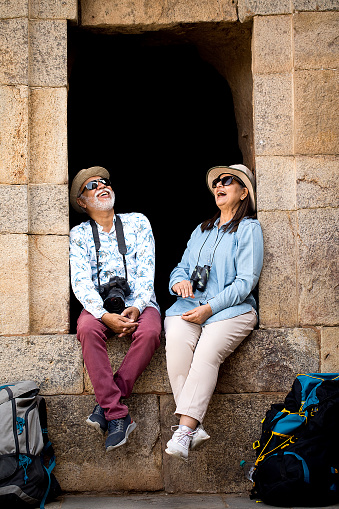 Senior couple spending leisure time together at the window of ancient structure during vacation post retirement