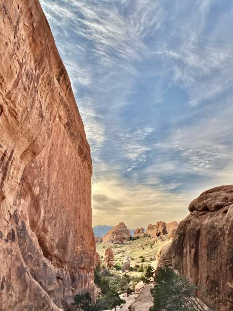 wandern entlang der glatten entrada-sandsteinwand-formationen des arches-nationalparks. - usa arches national park balanced rock colorado plateau stock-fotos und bilder