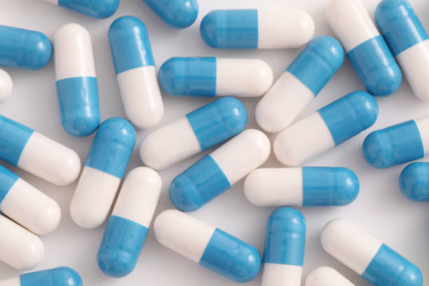 istock pills capsules close up on top view isolated in white background 1470978712