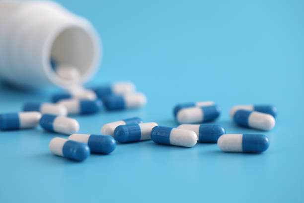 istock pills capsules with bottle isolated on blue background 1470978742