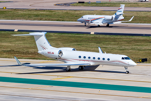 Dallas, United States – November 12, 2022: Gulfstream and Dassault Falcon private jets airplanes at Dallas Love Field airport (DAL) in the United States.