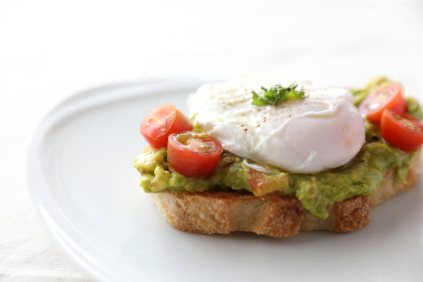 istock Poached eggs with avocado on toast in white background 1470981104