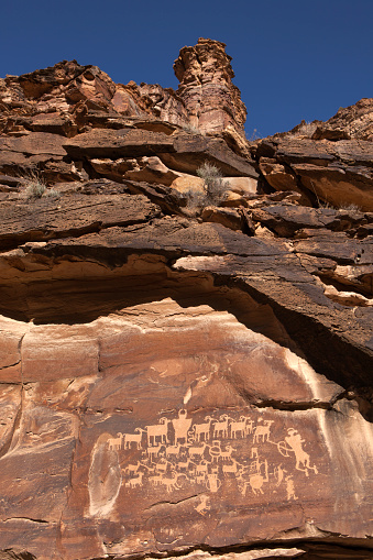 Pecked into the cliff, the Great Hunting Panel petroglyphs stand in Utah's Nine Mile Canyon. Made by the Fremont people about 1000 A.D., the scene shows bowmen or hunters with bighorn sheep.