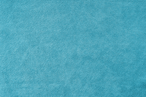 Texture background of velours turquoise fabric. Upholstery velveteen texture fabric, corduroy furniture textile material, design interior, decor. Ridge fabric texture close up, backdrop, wallpaper.