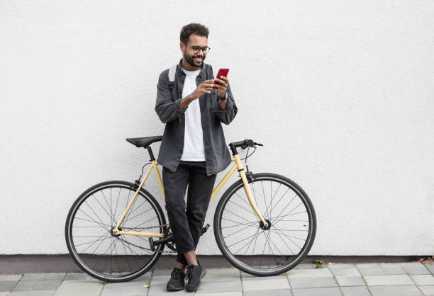 istock Happy man with bicycle using smart phone in a city 1470989744