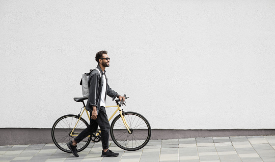 Smiling man riding a bike outdoor. Travel, people and active lifestyle concept