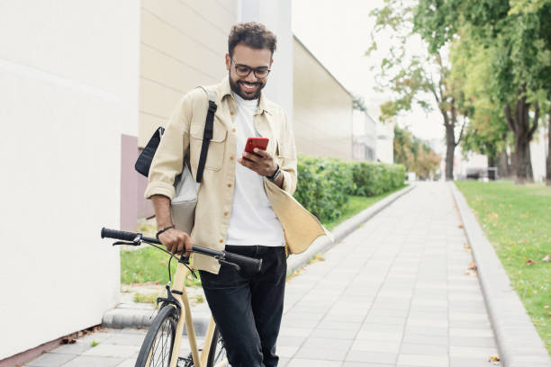 istock Happy young man with bicycle in a city 1470989794