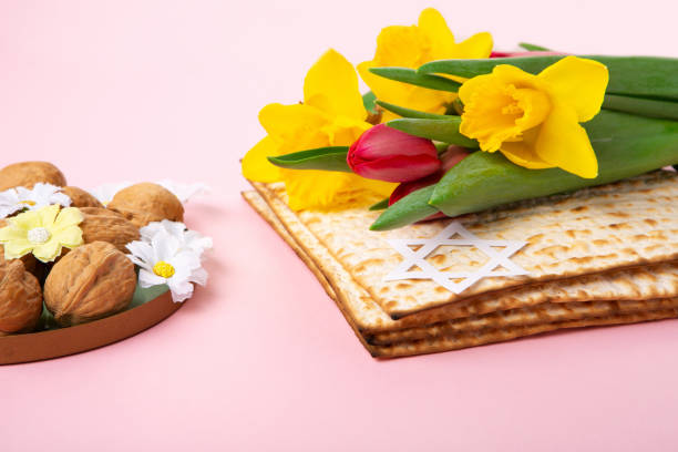 istock Passover Greeting Card with Matzah, Nuts and Spring Flowers on Pink Background. 1470989987