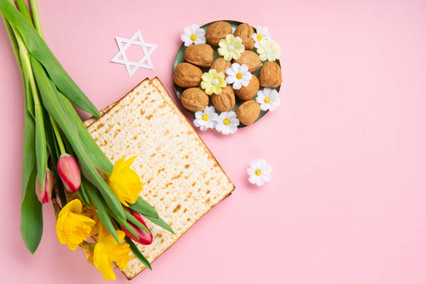 istock Passover Greeting Card with Matzah, Nuts and Spring Flowers on Pink Background. 1470989989