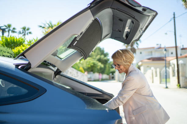 istock Woman looking in car trunk 1470990030