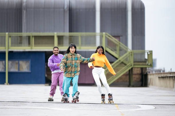 istock Smiling friends roller skating across concrete rooftop 1470990174