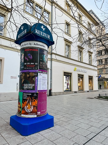 Stuttgart, Germany - February, 7 - 2023: Advertising pillar in the shopping district.