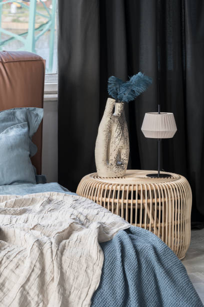 Rattan bedside table with decorative vase and lamp