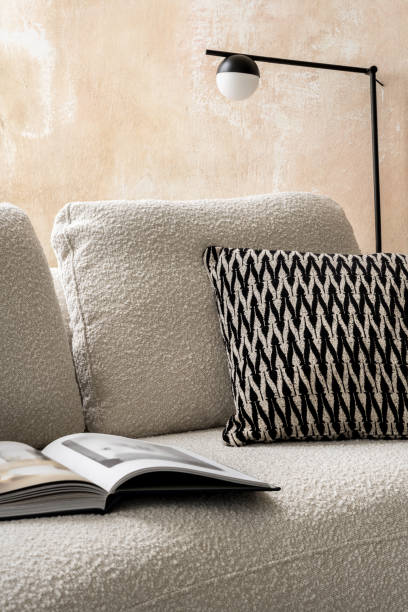 istock Elegant beige sofa with pillow and book 1470992068