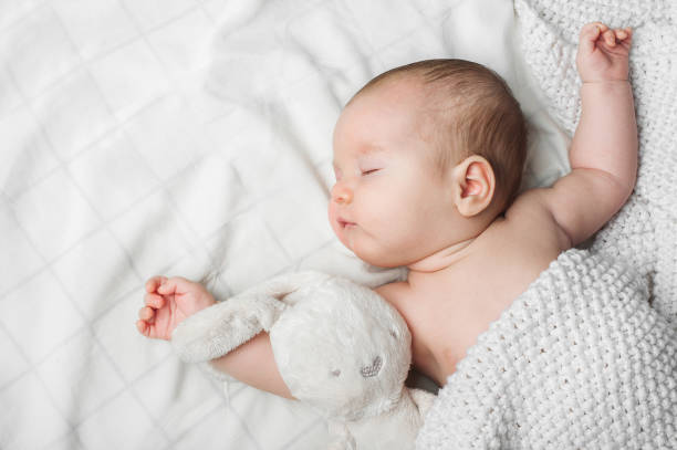 istock Sleeping newborn boy 2 months old with toy on white background close up and copy space 1470997486